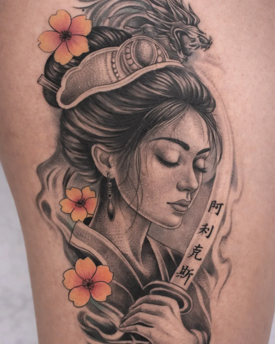 Portrait de geisha en noir et gris réaliste, rehaussé de fleurs d’hibiscus orange, sur le bras